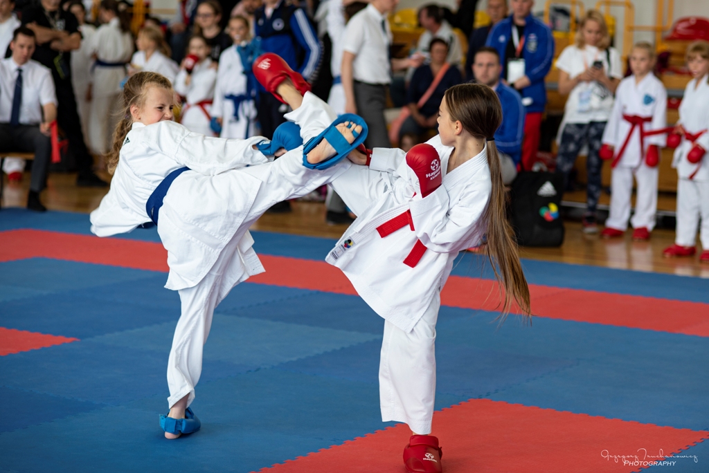 Walczące zawodniczki karate z czerwonym i niebieskim pasem