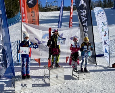 Czworo dzieci na podium, w rękach trzymają nagrody